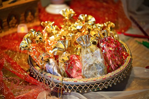 indian-wedding-favors-gold-red-white-pouches-brown-basket.jpg